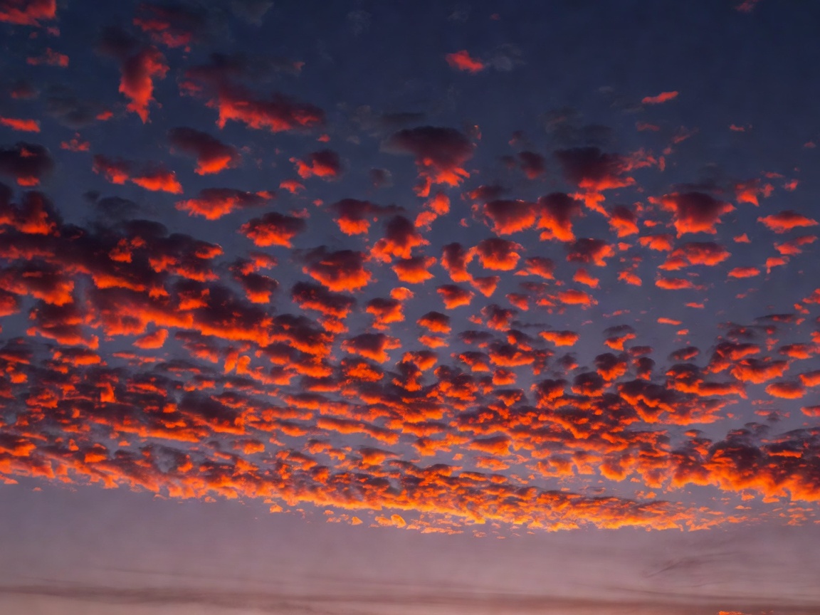 High Altocumulus Clouds Glowing Vibrant Orange and Red During Twilight
